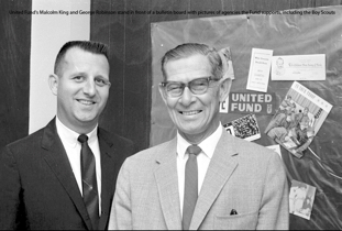 United Fund's Malcolm King and George Robinson stand in front of a bulletin board with pictures of agencies the Fund supports, including the Boy Scouts .tiff